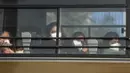 Sejumlah wanita India berada di dalam bus saat keluar dari Bandara Internasional Indira Gandhi setelah dievakuasi dari kota Wuhan di China, di New Delhi (1/2/2020). India mengevakuasi sekitar 250 warganya dari Wuhan, kota di Hubei yang merupakan pusat wabah virus corona. (AFP/Money Sharma)