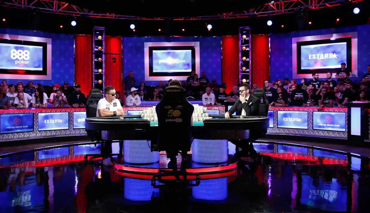 Pemain poker Hossein Ensan (kiri) dan Dario Sammartino (kanan) bermain dalam final World Series of Poker di Las Vegas, Amerika Serikat, Rabu (17/7/2019). Ensan adalah penduduk asli Iran yang berimigrasi ke Jerman 30 tahun lalu. (AP Photo/John Locher)