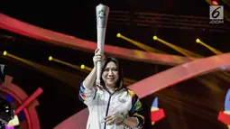 Mantan atlet bulutangkis Susi Susanti, memegang obor untuk Asian Games 2018 saat peluncuran Torch Asian Games dalam Konser 100 Hari Menuju Asian Games 2018 di Studio 6 Emtek, Jakarta, Kamis (10/5). (Liputan6.com/Faizal Fanani)