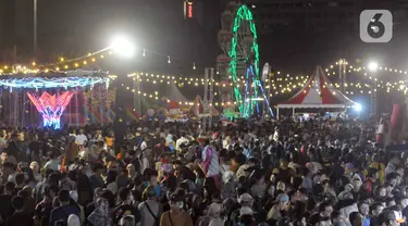 Warga antre naik wahana permainan komidi putar pada malam Jaya Raya Jakarnaval, atau Jakarta Night Carnaval Jakarta di kawasan Monumen Nasional, Sabtu (22/6/2024). (merdeka.com/Imam Buhori)