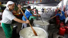 Sejumlah orang mengaduk Bubur Lambuk di desa Kampung Baru, Kuala Lumpur, Malaysia, Kamis (1/6). Bubur Lambuk adalah bubur yang terbuat dari beras dengan campuran rempah dan sayuran. (AP/Daniel Chan)