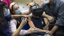 Seorang anak, Rafael Peled (8) melihat melalui kacamata realitas virtual VR saat menerima vaksin COVID-19 Pfizer-BioNTech di Rumah Sakit Sheba Tel Hashomer di Ramat Gan, Senin (22/11/2021). Israel mulai menyuntikkan vaksin Covid-19 pada anak usia 5 hingga 11 tahun. (AP Photo/Oded Balilty)