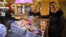 Seorang wanita yang mengenakan masker untuk membantu mengekang penyebaran virus corona COVID-19 melihat dekorasi Natal di GUM State Department Store, Moskow, Rusia, Senin (23/11/2020). Perayaan Natal Ortodoks di Rusia akan berlangsung pada 7 Januari. (AP Photo/Alexander Zemlianichenko)