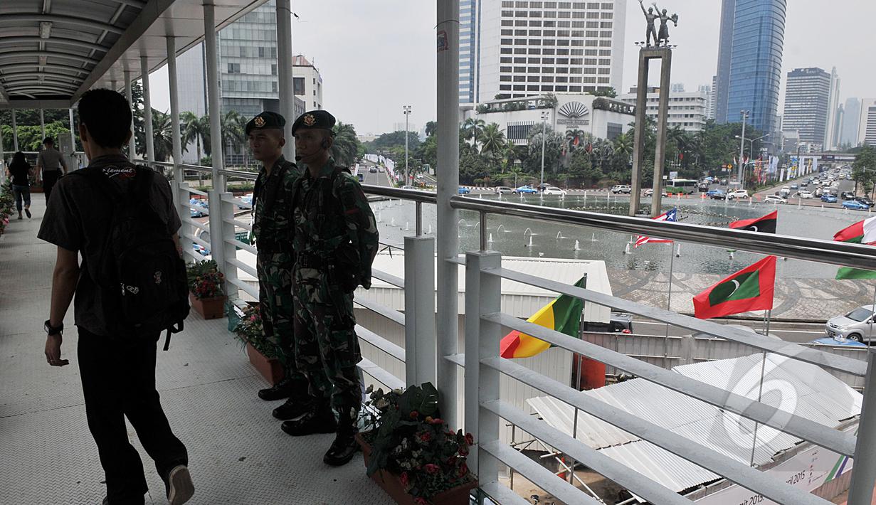 Sejumlah aparat keamanan terlihat berjaga di jembatan penyeberangan orang (JPO) kawasan Bundaran HI, Jakarta, Sabtu (18/4/2015). Sterilisasi dilakukan di tempat-tempat umum yang dilalui peserta Konferensi Asia Afrika (KAA). (Liputan6.com/Johan Tallo)