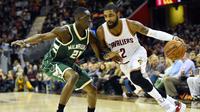 Pemain Cleveland Cavaliers, Kyrie Irving (kanan) menggiring bola melewati hadangan pemain Milwaukee Bucks, Tony Snell (kiri) pada laga NBA di Quicken Loans Arena, Cleveland, (21/12/2016). Cavaliers menang 113-102. (Reuters/Ken Blaze-USA TODAY Sports)