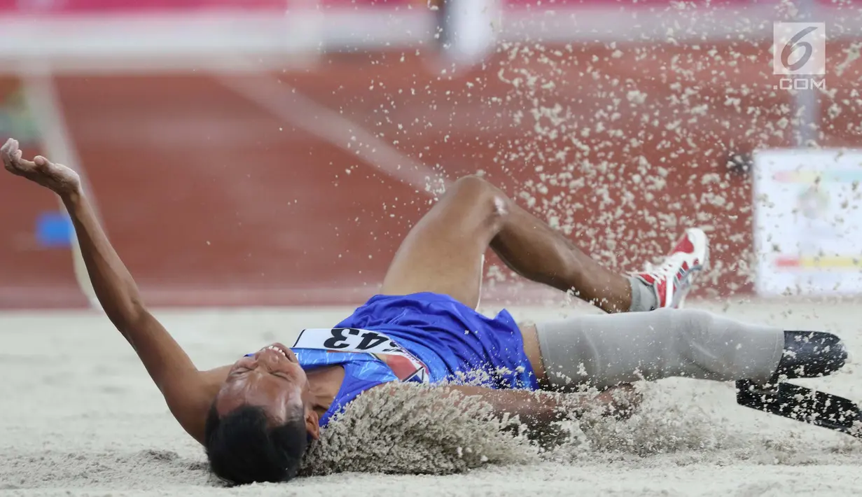 Atlet para atletik asal Myanmar, Kyaw Win Kyaw saat mendarat pada lomba lompat jauh T44, T62/T64 putra Asian Para Games 2018 di Stadion Utama Gelora Bung Karno, Jakarta, Jumat (12/10). (Liputan6.com/Helmi Fithriansyah)
