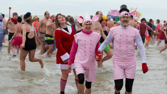 Orang-orang menceburkan diri ke perairan Laut Utara untuk merayakan akhir pekan pertama Januari 2020 di Ostend, Belgia, Sabtu (4/1/2020). Tak sekedar bermain air, sejumlah warga Belgia juga beraksi dengan kostum warna-warni yang menjadi salah satu tradisi tahun baru. (NICOLAS MAETERLINCK/BELGA/AFP)