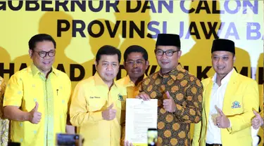 Ketua Umum Golkar Setya Novanto, Ridwan Kamil dan Daniel Muttaqien berfoto bersama menunjukan surat keputusan (SK) pengusungan usai pengumuman Calon Gubernur dan Wakil Gubernur Jawa Barat di DPP Golkar, Jakarta, Kamis (9/11). (Liputan6.com/Johan Tallo)