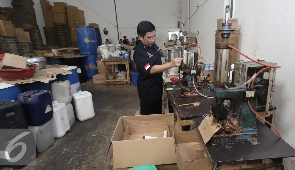 Direktur IV Narkotika Bareskrim Polri Brigjen Pol Anjan Pramuka Putra memeriksa alat produksi yang digunakan untuk membuat palsu di pergudangan Surya Balaraja, Tangerang, Kamis (26/11). (Liputan6.com/Angga Yuniar)