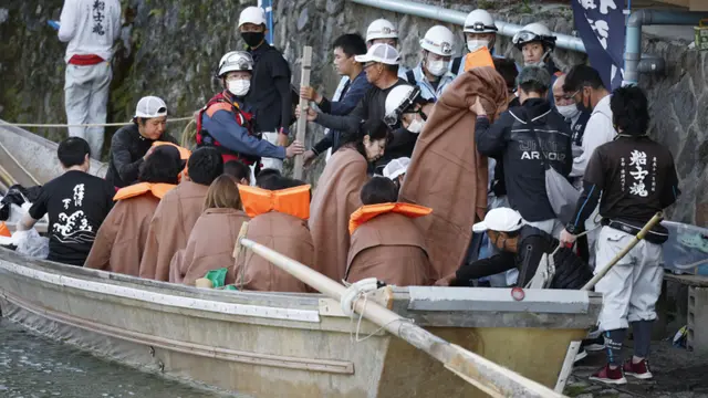 Orang-orang turun di Arashiyama di Kyoto setelah diangkut dari daerah tempat perahu kayu tradisional yang membawa 29 orang dalam pelayaran sungai pada 28 Maret 2023.