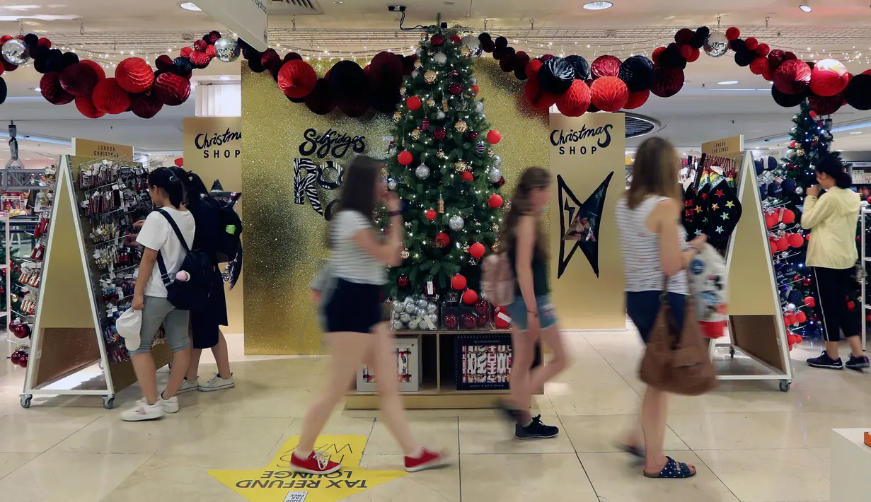 Pengunjung melintasi pohon natal di toko Selfridges, London, Senin (6/8). Selfridges yang meruapak salah satu toko terkenal di Inggris sudah membuka gerainya yang berisi ratusan ornamen dan perlengkapan natal pada bulan Agustus. (AP/Robert Stevens)