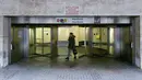 Seorang warga berjalan di depan Stasiun Metro Maelbeek pada hari pembukaan di Brussels, Ibu Kota Belgia, Senin (25/4). Stasiun kereta metro tersebut akhirnya dibuka kembali setelah serangan bom 22 Maret 2016 lalu yang menewaskan 35 orang. (JOHN Thys /AFP)