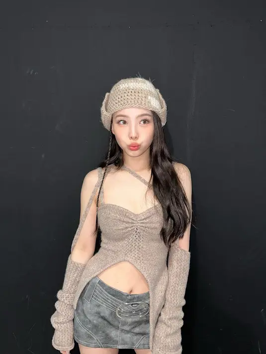 Gaya Y2K kece salah satunya bisa kamu sontek dari potret penampilan Nayeon TWICE satu ini. Padukan cut out top dengan mini skirt dan topi rajut. [@nayeonyny]