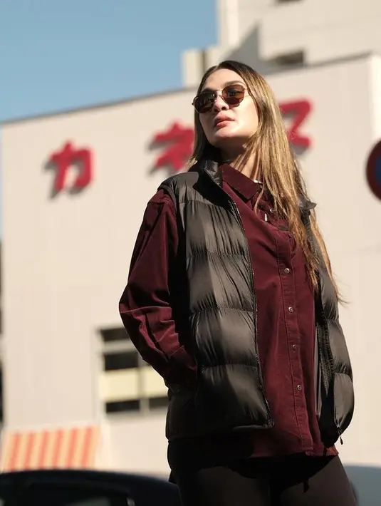 Luna Maya menikmati suasana musim gugur di Jepang. Ia mengenakan kemeja berwarna burgundy yang dipadukan dengan puffer vest dan legging pants. [instagram/lunamaya]