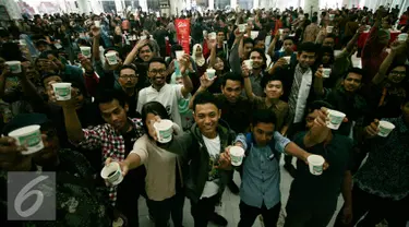 Para pengunjung menikmati kopi pada International Coffee Day di kawasan Babarsari, Yogyakarta, Sabtu (1/10). Panitia membagikan 10.000 kopi kepada pengunjung secara gratis pada peringatan hari kopi sedunia. (Liputan6.com/Boy Harjanto)