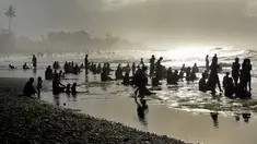 Sejumlah warga menjalani prosesi menyucikan diri saat Hari Banyu Pinaruh di pantai Keramas, Gianyar, Bali, Minggu (12/5/2019). Hari Banyu Pinaruh merupakan hari yang diyakini oleh umat Hindu sebagai waktu yang baik untuk menyucikan diri secara spritual dengan mandi di mata air  (SONNY TUMBELAKA/AFP)