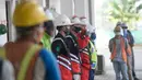 Pekerja mengenakan masker saat mengerjakan proyek pembangunan integrated building Bandara Internasional Soekarno-Hatta, Tangerang, Banten, Rabu (29/7/2020). Pembangunan gedung penghubung stasiun Bandara Soetta dan jembatan itu sudah mencapai 44,4 persen. (merdeka.com/Dwi Narwoko)