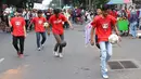 Aksi sejumlah pria memainkan bola saat melakukan karnaval di jalan Pintu 1 Senayan, Jakarta, Minggu (24/9). Karnaval tersebut dilakukan dalam rangka HUT Gelora Bungkarno yang ke-55. (Liputan6.com/Angga Yuniar)