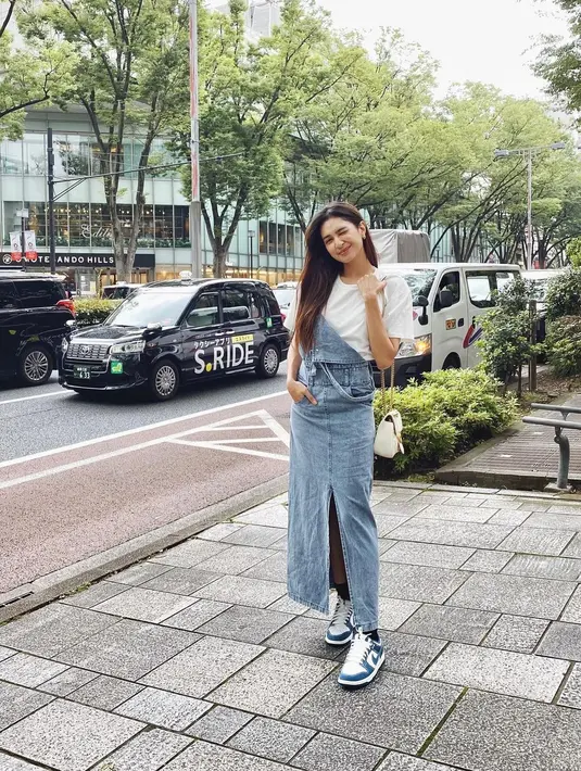 Potret menarik dari Mikha Tambayong saat berlibur ke Jepang. Di sini ia mengenakan atasan kaus putih polos, dipadu dengan denim jumpsuit, dan memilih mengenakan sneakers favoritnya yang serasi. Foto: Instagram.
