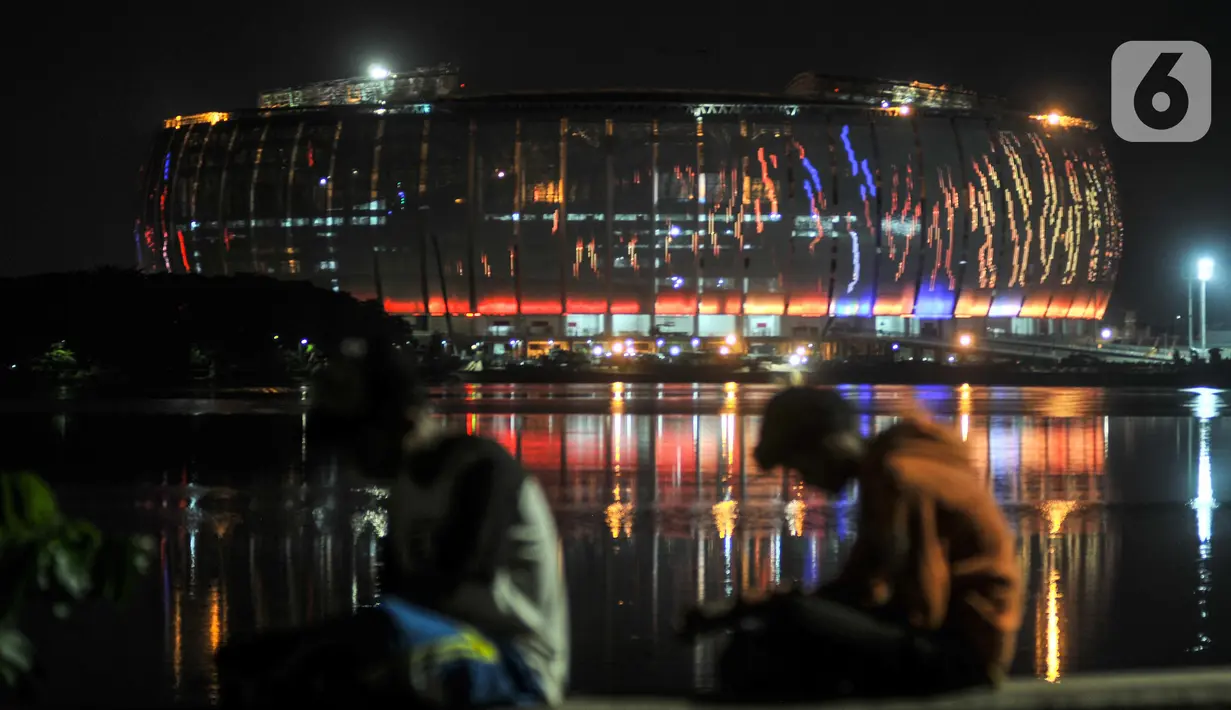 Warna-warni lampu Jakarta International Stadium (JIS) terlihat dari Waduk Cincin, Papanggo, Jakarta Utara, Rabu (16/3/2022). PT Jakarta Propertindo (Jakpro) menargetkan pembangunan JIS rampung dan siap dibuka pada April 2022. (merdeka.com/Iqbal S. Nugroho)