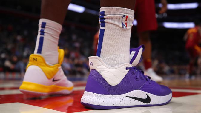 Pemain Detroit Pistons Reggie Jackson mengenakan sepatu kuning-ungu untuk menghormati mantan Kobe Bryant saat melawan Cleveland Cavaliers di Little Caesars Arena, Michigan (27/1/2020). Kobe menghabiskan kariernya selama 20 tahun bersama LA Lakers. (Gregory Shamus/Getty Images/AFP)