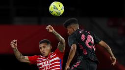 Striker Granada, Darwin Machis (kiri) berduel udara dengan gelandang Real Madrid, Marvin Park dalam laga lanjutan Liga Spanyol 2020/2021 pekan ke-36 di Los Carmenes Stadium, Granada, Kamis (13/5/2021). Granada kalah 1-4 dari Real Madrid. (AP/Fermin Rodriguez)