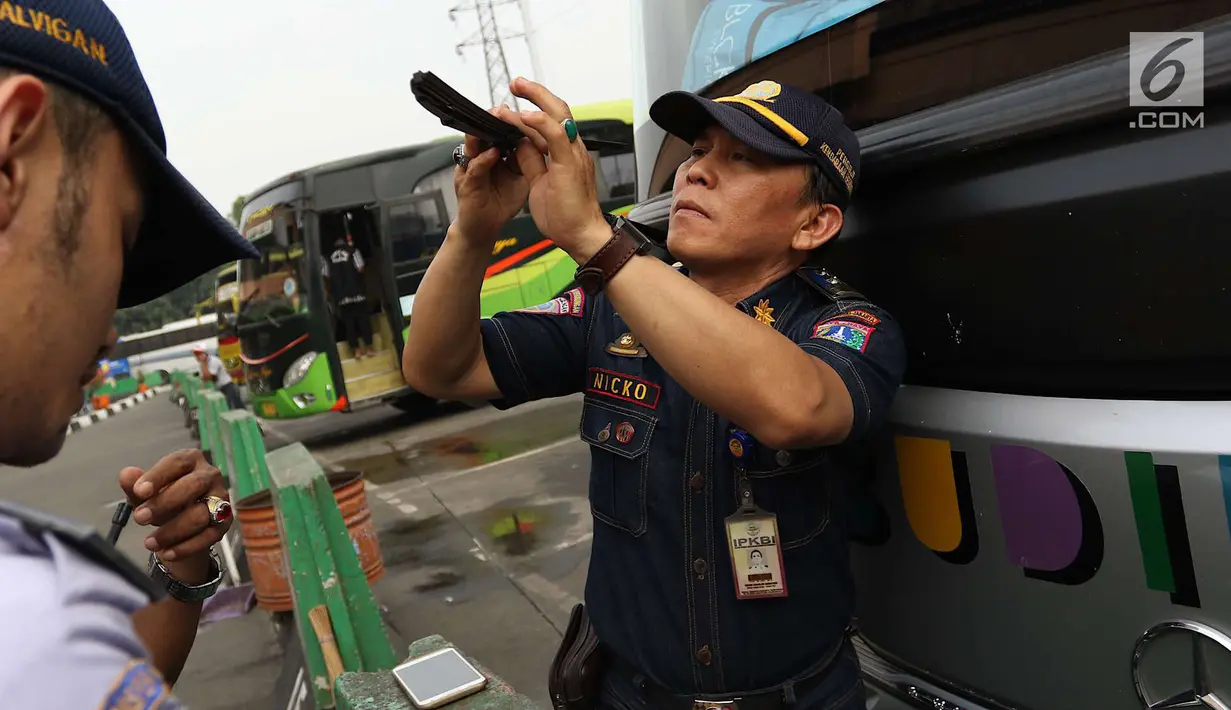 Petugas Dinas Perhubungan (Dishub) DKI Jakarta mengecek kesiapan angkutan mudik Lebaran di Terminal Kampung Rambutan, Jakarta, Jumat (8/6). Menurut Dishub, dari 37 bus yang dicek ada 26 dinyatakan tidak lulus uji kelaikan. (Liputan6.com/Immanuel Antonius)