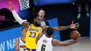 Pebasket Los Angeles Lakers, LeBron James, berusaha menghadang pemain Denver Nuggets, Keita Bates-Diop, pada laga NBA di The Arena, Senin (11/8/2020). LA Lakers menang dengan skor 124-121. (AP Photo/Ashley Landis, Pool)