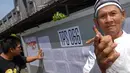 Pria paruh baya ini memperlihatkan jari kelingkingnya sebagai bukti bahwa ia sudah menggunakan hak suaranya (Liputan6.com/ Miftahul Hayat).
