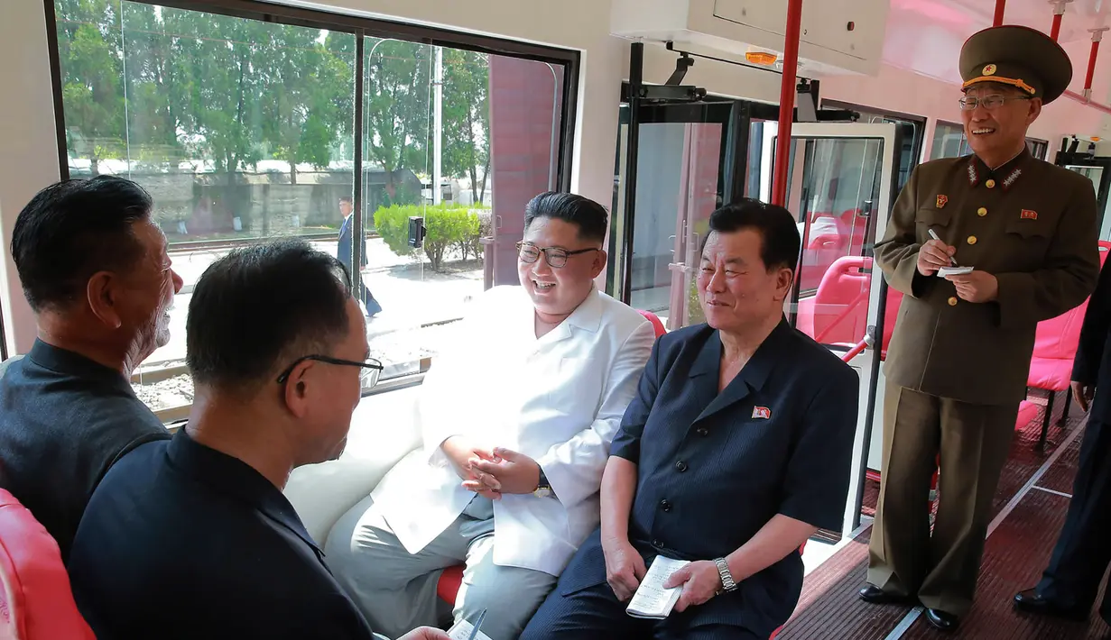 Pemimpin Korea Utara Kim Jong-Un tersenyum saat duduk di dalam bus jenis baru yang diproduksi selama kunjungan ke pabrik bus di Pyongyang, (4/8). (AFP Photo/KCNA)