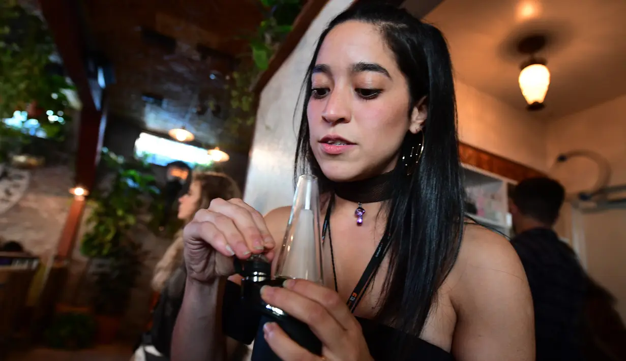 Erika Soto memegang alat oleskan dari Puffco sehari sebelum pembukaan resminya di Lowell Cafe di Hollywood Barat, California  (30/9/2019). Kafe ganja pertama di Amerika telah dibuka di Hollywood Barat. (AFP Photo/Frederic J. Brown)