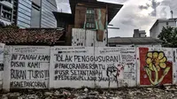 Mural dan berbagai coretan kritis warga menghiasi tembok pembatas di Jalan Pancoran Buntu II, Pancoran, Jakarta Selatan, Minggu (21/3/2021). Pihak Pertamina juga mendirikan tembok pembatas, kemudian warga berhasil merebut kembali namun berujung bentrokan dengan ormas. (merdeka.com/Iqbal S. Nugroho)