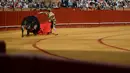Matador asal Spanyol, Jose Maria Manzanares saat bertarung dengan banteng di arena adu banteng Real Maestranza di Sevilla, Spanyol (21/4). (AFP Photo/Cristina Quicler)