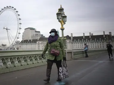 Seorang pejalan kaki berjalan di atas Jembatan Westminster di London, Senin (10/1/2022). Penasihat pemerintah Inggris telah merekomendasikan untuk tidak memberikan dosis keempat vasksin Covid-19 bagi kelompok usia di atas 80 tahun atau lansia. (AP Photo/Kirsty Wigglesworth)