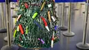 Pohon Natal yang dirakit dari barang-barang sitaan di Bandara Vilnius, Lithuania pada 12 Desember 2019. Pohon Natal unik tersebut dibuat dari barang-barang sitaan yang dilarang dibawa ke kabin pesawat. (Photo by Petras Malukas / AFP)