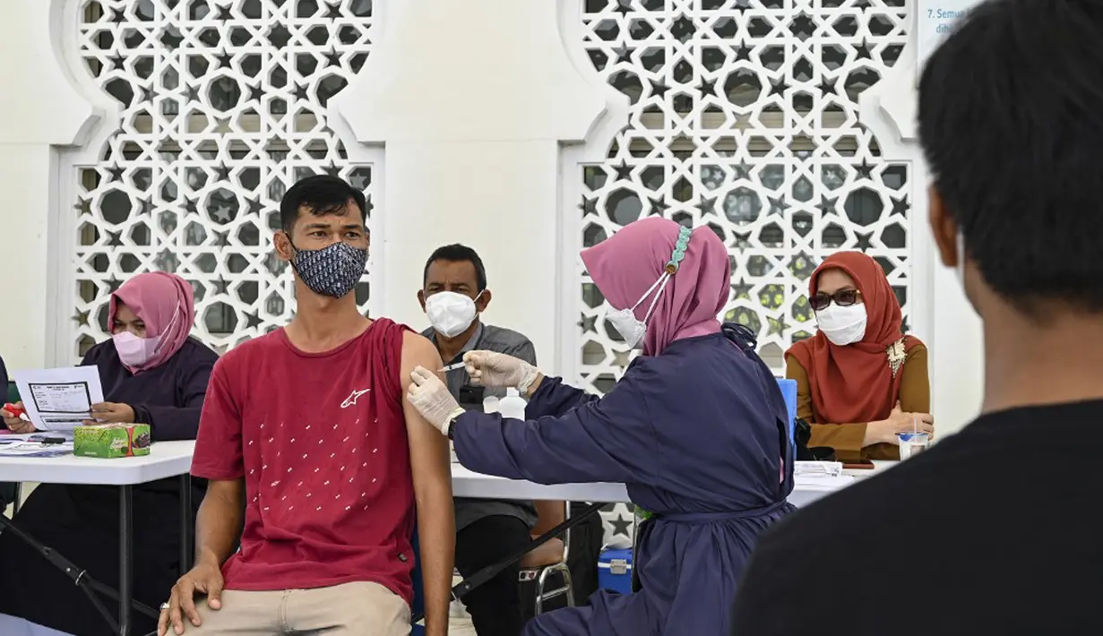 Seorang pria menerima dosis vaksin virus corona COVID-19 Sinovac saat pelaksanaan vaksinasi di Masjid Raya Baiturrahman, Banda Aceh, Aceh, Selasa (7/9/2021). (CHAIDEER MAHYUDDIN/AFP)