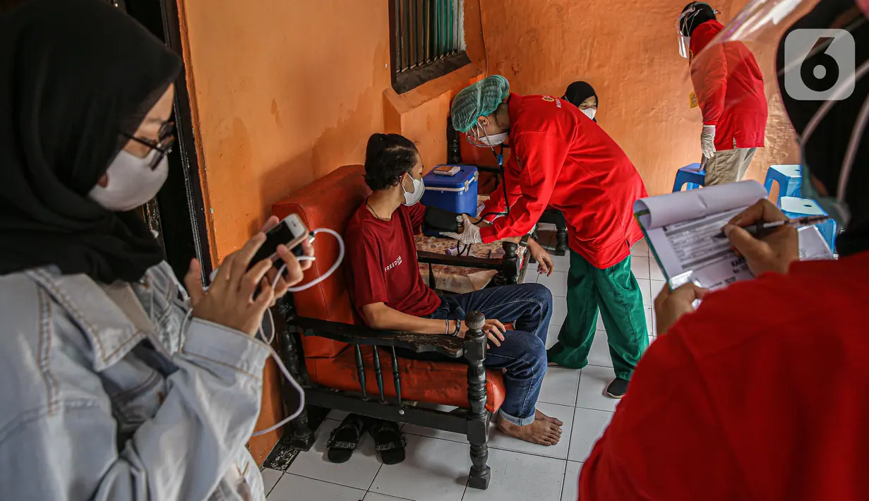 Petugas medis mengecek kesehatan warga sebelum divaksin COVID-19 di Bogor, Jawa Barat, Rabu (14/7/2021). Metode vaksinasi door to door telah mampu meningkatkan partisipasi vaksinasi karena dapat menjangkau keluarga yang belum mempunyai akses dan takut keluar rumah. (Liputan6.com/Faizal Fanani)
