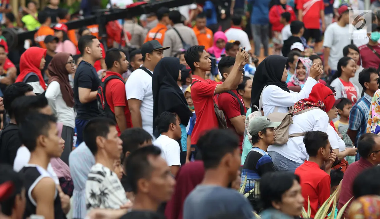 Salah satu warga mengabadikan peresmian pengoperasian Moda Raya Terpadu Jakarta fase 1 di Kawasan Bundaran HI, Jakarta, Minggu (24/3). Peresmian dilakukan oleh Presiden Joko Widodo, Gubernur DKI Jakarta, Anies Baswedan serta pihak terkait. (Liputan6.com/Helmi Fithriansyah)