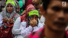 Sejumlah guru honorer Kategori 2 beristigosah saat menggelar aksi di depan gedung MPR/DPR, Jakarta, Senin (23/7). Aksi tersebut untuk mendukung proses penyelesaian atau penentuan nasib para honorer K2 yang sedang dirapatkan. (Liputan6.com/JohanTallo)