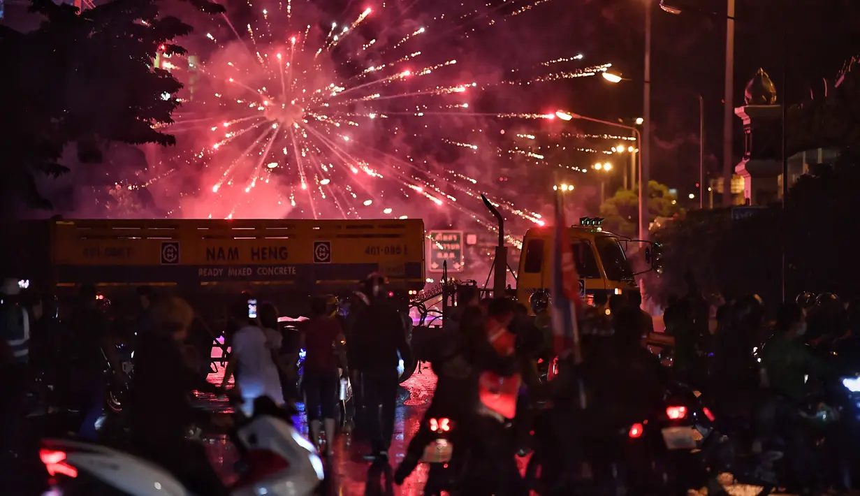 Pengunjuk rasa anti-pemerintah meluncurkan petasan ke arah polisi selama demonstrasi di Bangkok, Thailand, Minggu (6/9/2021). Aksi unjuk rasa yang menyuarakan pengunduran diri Perdana Menteri Thailand, Prayut Chan-O-Cha makin mencekam hingga malam hari. (AFP/Jack Taylor)