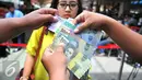 Beberapa pecahan uang baru yang sudah dikeluarkan oleh Bank Indonesia yang dapat ditukarkan di Blok M, Jakarta, Senin (19/12). Bank Indonesia (BI) hari ini meluncurkan 11 uang rupiah Emisi 2016 dengan gambar pahlawan baru. (Liputan6.com/Angga Yuniar)