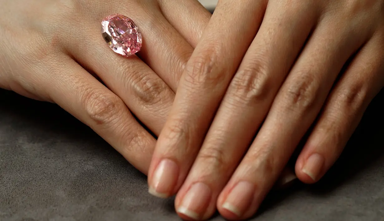 Model memperlihatkan berlian berwarna purple pink yang sangat langka di ruang lelang Sotheby Hong Kong pada 12 Oktober 2020. Berlian berbentuk oval yang ditemukan di pertambangan Rusia ini akan dilelang pada 11 November mendatang di Jenewa. (AP Photo/Vincent Yu)