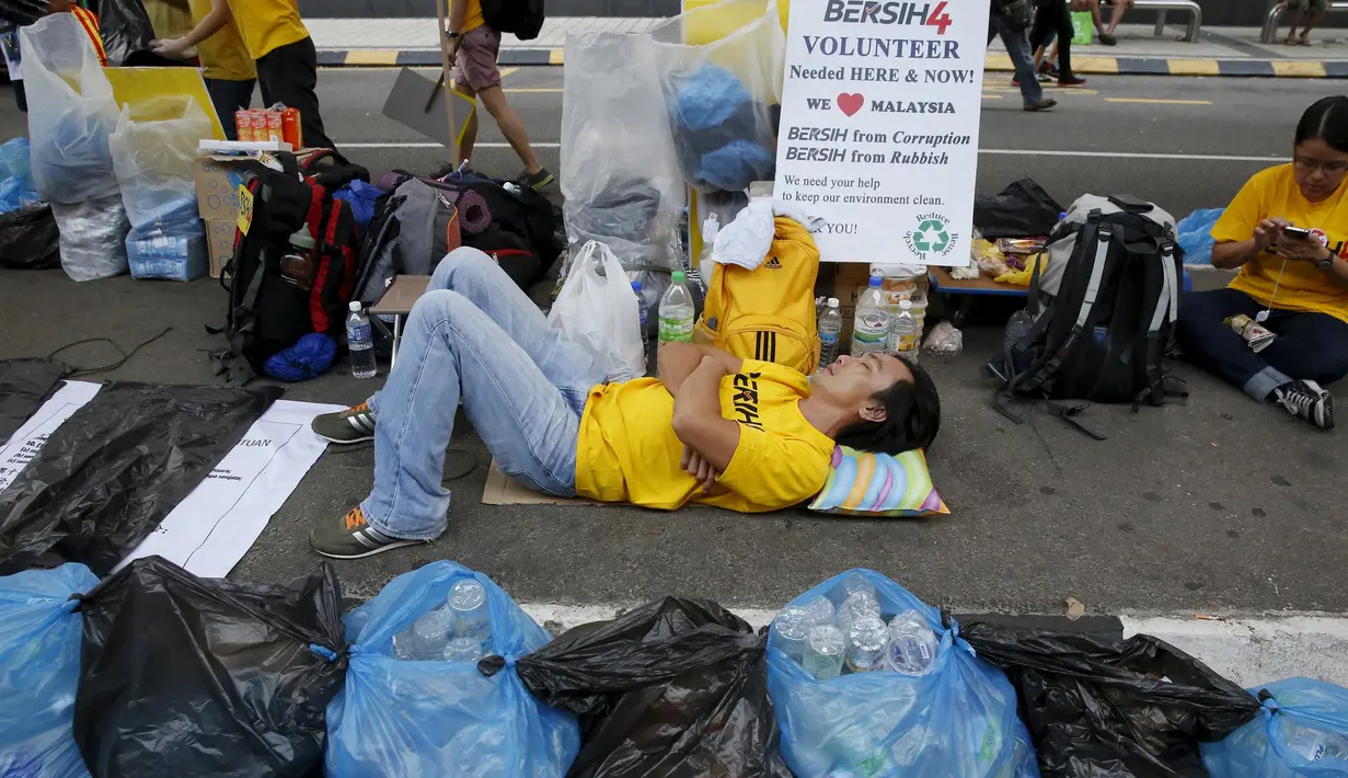 Seorang pengunjuk rasa tertidur diantara kantong plastik saat aksi gerakan Bersih 4.0 di ibukota Malaysia, Kuala Lumpur, Minggu (30/8/2015). Aksi tersebut menuntut pengunduran diri PM Malaysia Najib Razak terkait tuduhan korupsi. (REUTERS/Olivia Harris)