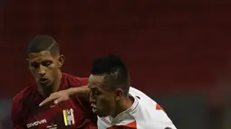 Gelandang timnas Peru, Christian Cueva berebut bola dengan gelandang Venezuela, Edson Castillo pada laga terakhir penyisihan Grup B  Copa America 2021 di Estadio Nacional Mane Garrincha, Minggu (27/6/2021). Menghadapi Venezuela, Peru menang tipis dengan skor 1-0. (AP Photo/Bruna Prado)