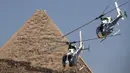 Helikopter Hel Gazelle dari tim aerobatik "Horus" Angkatan Udara Mesir tampil melewati Pyramid of Khafre selama Pyramids Air Show 2022 di Giza Pyramids Necropolis, Mesir, 3 Agustus 2022. (Mahmoud Khaled/AFP)