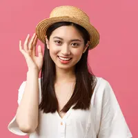 Seorang perempuan menggunakan sebuah topi anyam (Foto Dok: Freepik/benzoix).