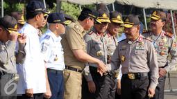 Kapolri Jenderal Badrodin Haiti bersalaman dengan Gubernur DKI Jakarta, Basuki T Purnama saat apel gelar pasukan operasi ketupat 2015 di Mapolda Metro Jaya, Jakarta, Kamis (9/7/2015).  (Liputan6.com/Helmi Afandi)