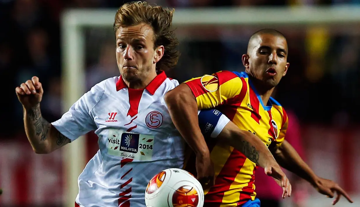 Gelandang Sevilla, Ivan Rakitic (kiri) berusaha menghalangi pergerakan pemain Valencia, Sofiane Feghouli di laga pertama semifinal Liga Europa di Seville, (25/4/2014) (REUTERS/Marcelo del Pozo)