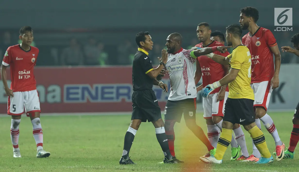 Pemain depan Persipura, Boaz Salossa (ketiga kiri) melakukan protes kepada wasit Yeni Krisdianto saat melawan Persija dilanjutan Liga 1 Indonesia di Stadion Patriot Candra Bhaga, Bekasi, Sabtu (8/7). Laga berakhir 1-1. (Liputan6.com/Helmi Fithriansyah)