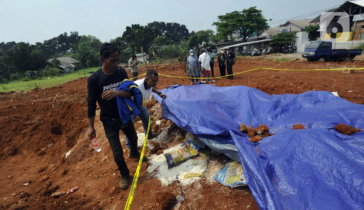 Warga memeriksa tempat penemuan beras diduga bansos presiden di kawasan Kampung Serab, Sukmajaya, Depok, Jawa Barat, Rabu (3/8/022). Dari berita acara pemendaman, diketahui beras yang dikubur sebanyak 3.675 kg atau 289 karung. (merdeka.com/Arie Basuki)